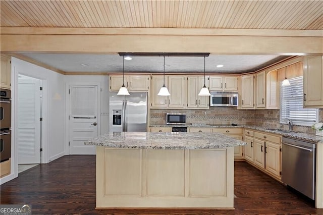 kitchen featuring light stone counters, a kitchen island, and appliances with stainless steel finishes