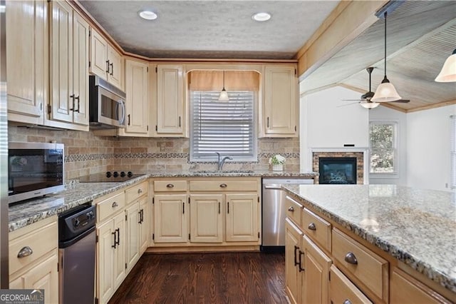 kitchen with appliances with stainless steel finishes, pendant lighting, sink, ceiling fan, and dark wood-type flooring