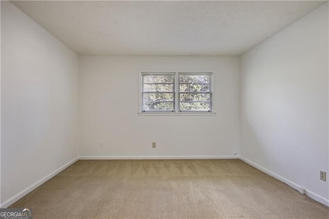 unfurnished room featuring light colored carpet