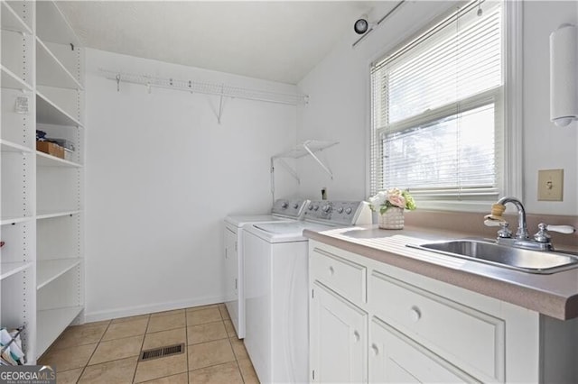 clothes washing area featuring sink, light tile patterned floors, and washing machine and clothes dryer