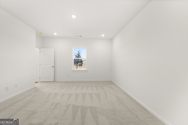 unfurnished room featuring light carpet