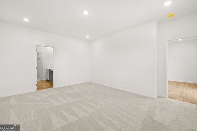 unfurnished room featuring light carpet