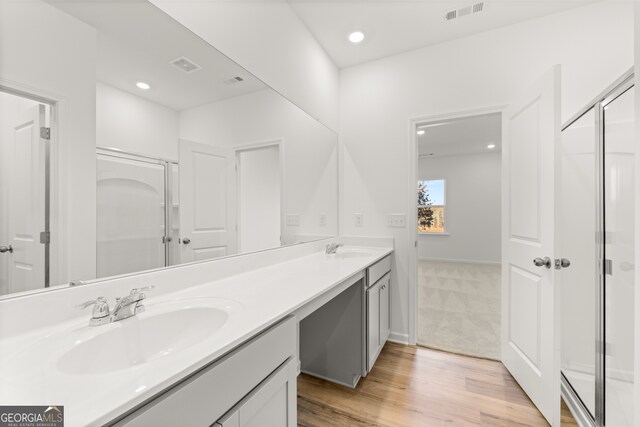 bathroom featuring vanity, an enclosed shower, and wood-type flooring