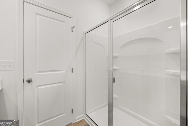 bathroom with wood-type flooring and walk in shower