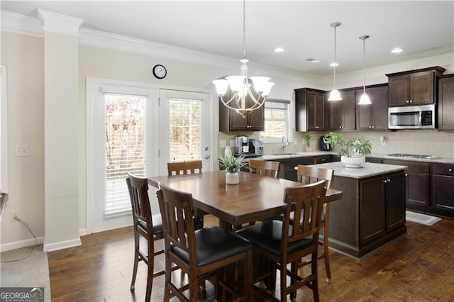 dining room featuring crown molding, sink, a chandelier, and dark hardwood / wood-style floors