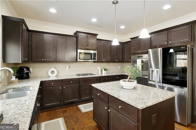 kitchen featuring a center island, sink, hanging light fixtures, dark hardwood / wood-style floors, and stainless steel appliances