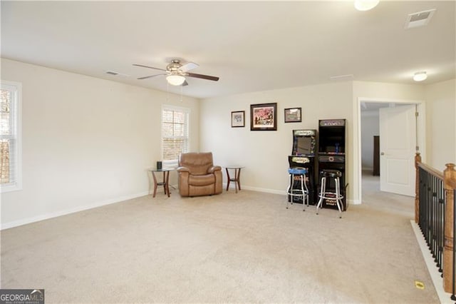 living area with ceiling fan and light carpet