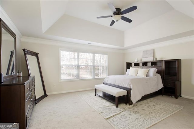 bedroom featuring ceiling fan, light carpet, and a tray ceiling