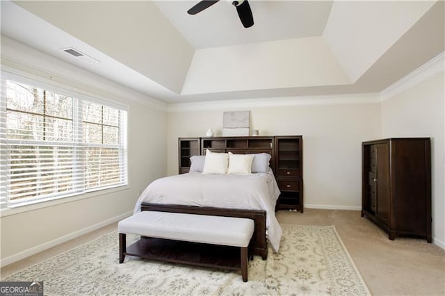 carpeted bedroom featuring a tray ceiling, ceiling fan, and crown molding