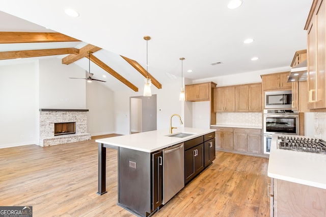 kitchen featuring stainless steel appliances, a kitchen island with sink, sink, lofted ceiling with beams, and light hardwood / wood-style floors