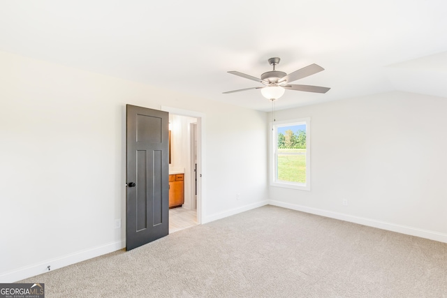 unfurnished bedroom with light colored carpet, ceiling fan, lofted ceiling, and ensuite bathroom