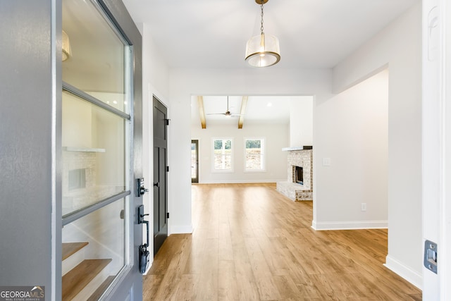 hallway featuring beam ceiling and light hardwood / wood-style floors