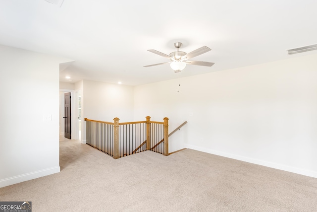 spare room featuring light carpet and ceiling fan