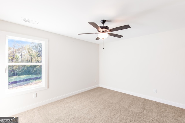 spare room featuring ceiling fan and carpet