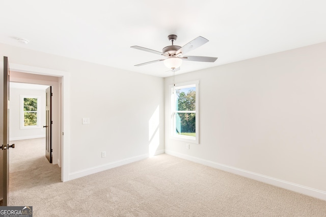 empty room with light colored carpet and ceiling fan