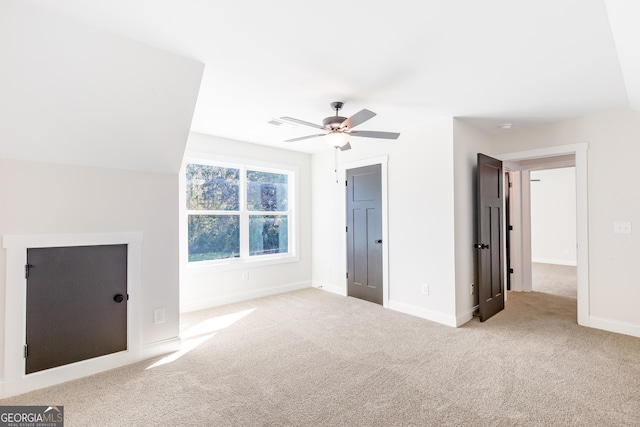 unfurnished bedroom with ceiling fan, light carpet, and vaulted ceiling