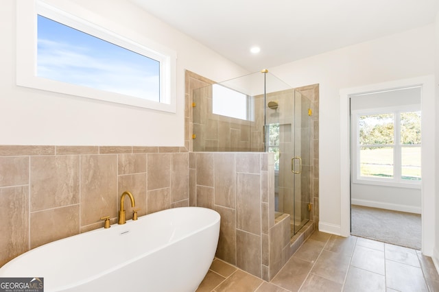 bathroom with separate shower and tub, tile patterned floors, and a healthy amount of sunlight