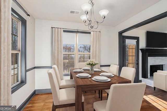 dining area with hardwood / wood-style flooring and an inviting chandelier