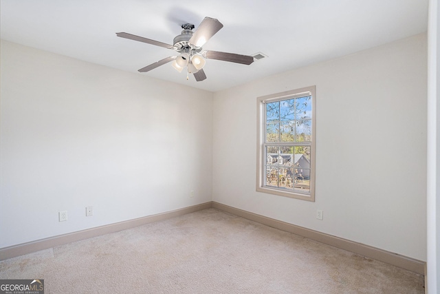 unfurnished room with ceiling fan and carpet