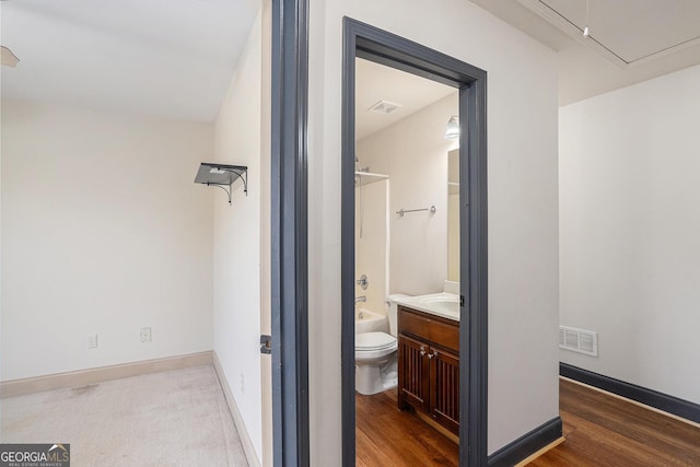 full bathroom with hardwood / wood-style flooring, vanity,  shower combination, and toilet