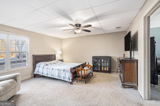 carpeted bedroom with a drop ceiling and ceiling fan