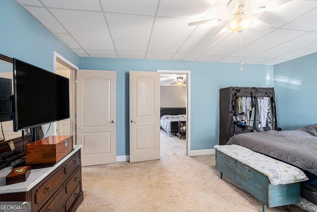 bedroom featuring a paneled ceiling, ceiling fan, and light carpet