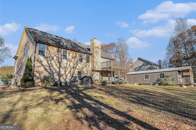 back of house with a yard, a balcony, and central AC unit