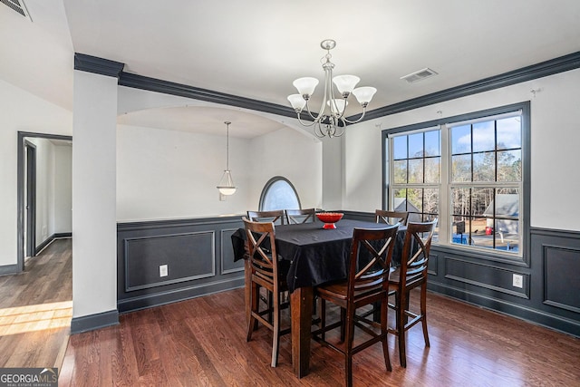 dining space with crown molding, dark hardwood / wood-style floors, and a notable chandelier