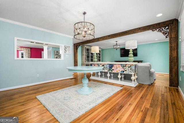 playroom featuring wood-type flooring, an inviting chandelier, and ornamental molding