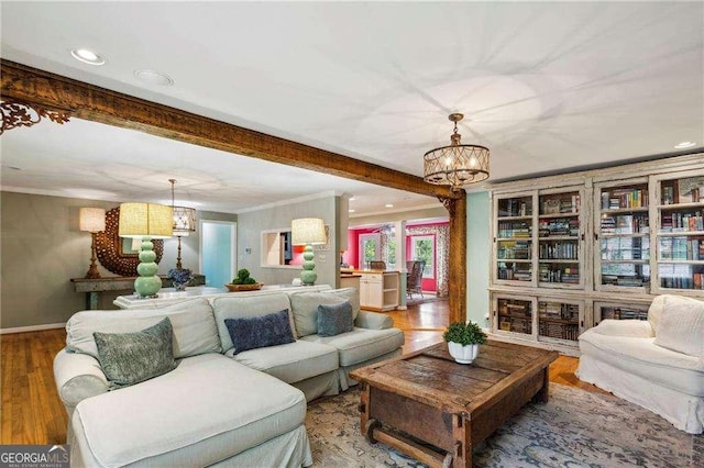 living room featuring a chandelier, beam ceiling, ornamental molding, and wood-type flooring