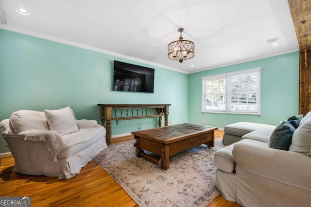 living room featuring hardwood / wood-style floors, ornamental molding, and a chandelier