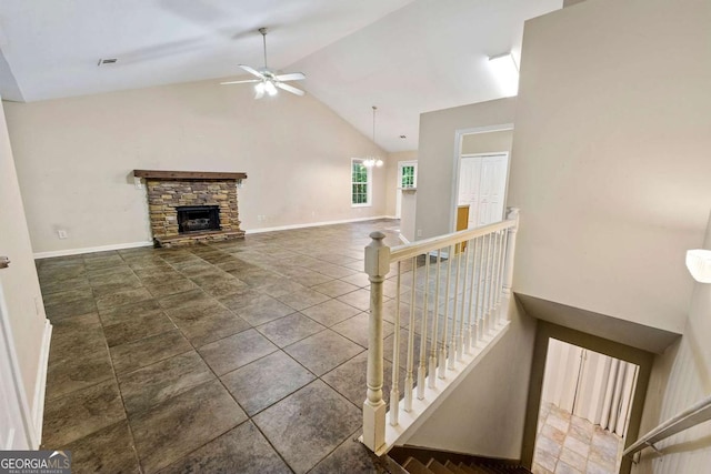 tiled living room with high vaulted ceiling, ceiling fan, and a stone fireplace