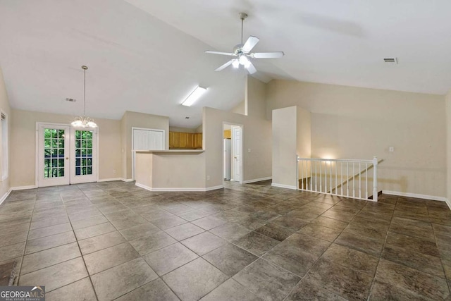 unfurnished living room with dark tile patterned floors, high vaulted ceiling, and ceiling fan with notable chandelier