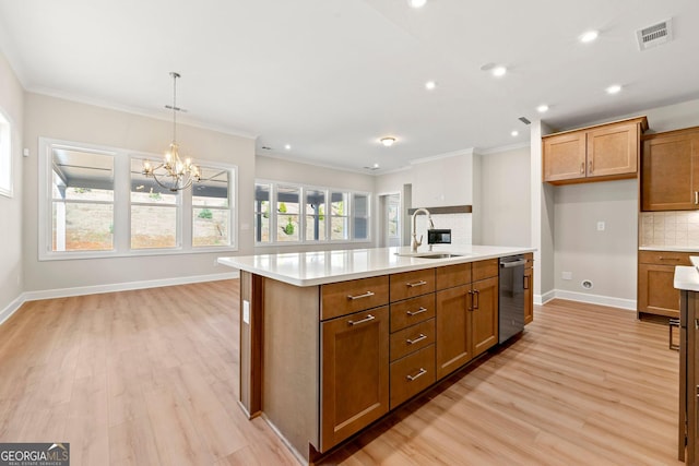 kitchen with tasteful backsplash, visible vents, stainless steel dishwasher, brown cabinetry, and a sink