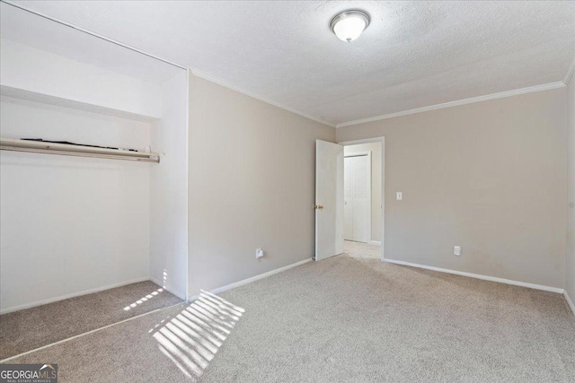 unfurnished bedroom featuring a textured ceiling, light colored carpet, a closet, and ornamental molding