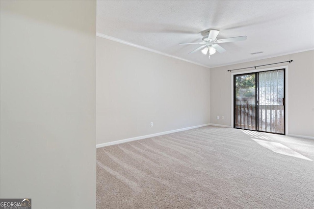 carpeted spare room with a textured ceiling, ceiling fan, and ornamental molding