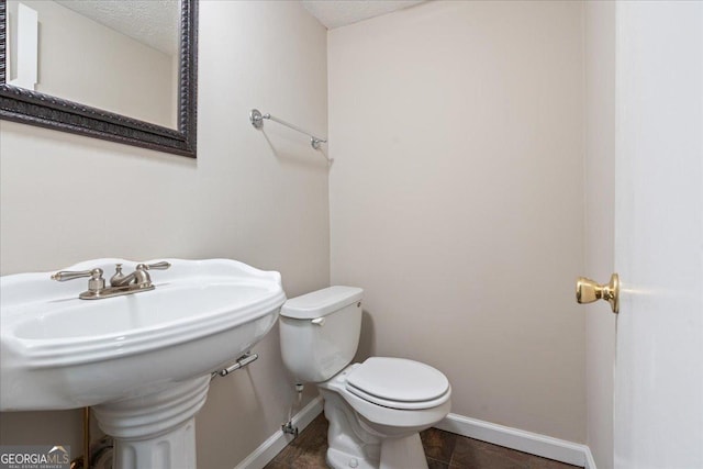 bathroom with a textured ceiling and toilet