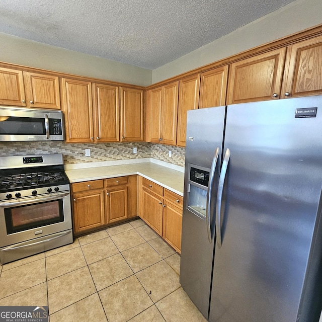 kitchen featuring light tile patterned floors, backsplash, and stainless steel appliances