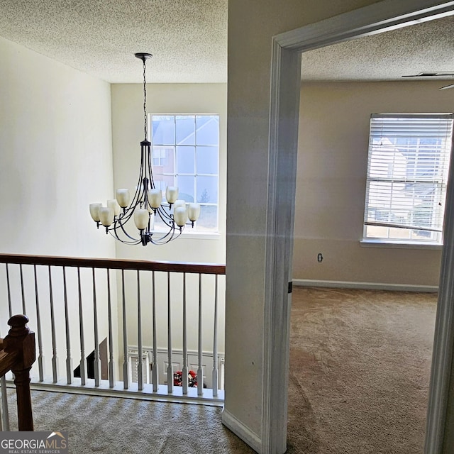 interior space with carpet flooring, a chandelier, and a textured ceiling