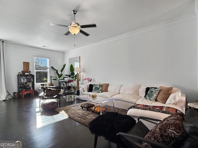 living room with crown molding, ceiling fan, and dark wood-type flooring