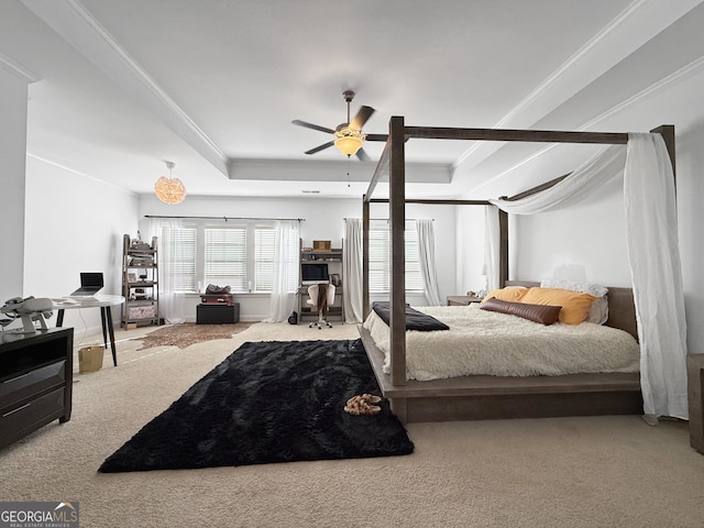 carpeted bedroom featuring a tray ceiling, ceiling fan, and ornamental molding