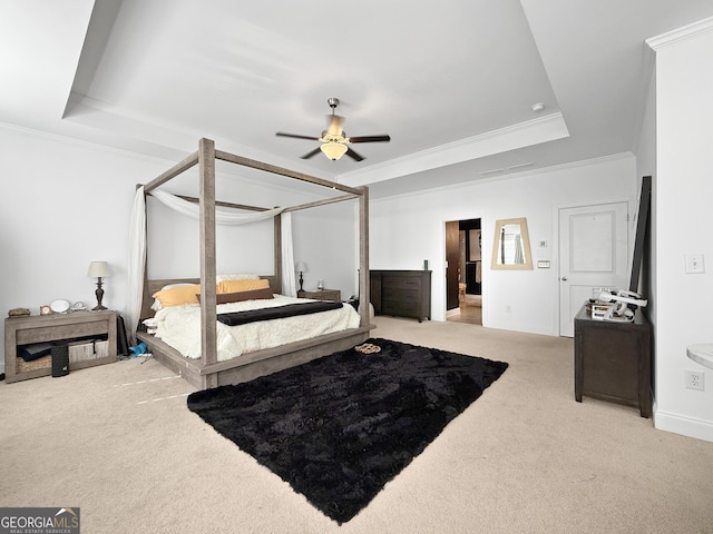 carpeted bedroom featuring a raised ceiling, ceiling fan, and ornamental molding