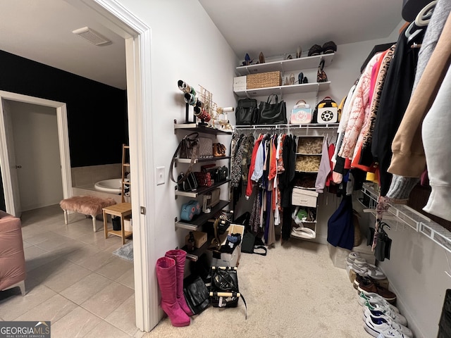 walk in closet with light tile patterned floors