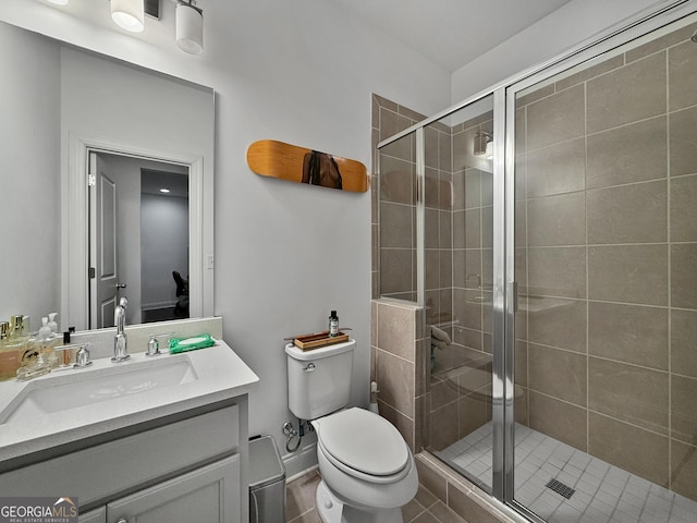 bathroom featuring tile patterned floors, vanity, toilet, and walk in shower