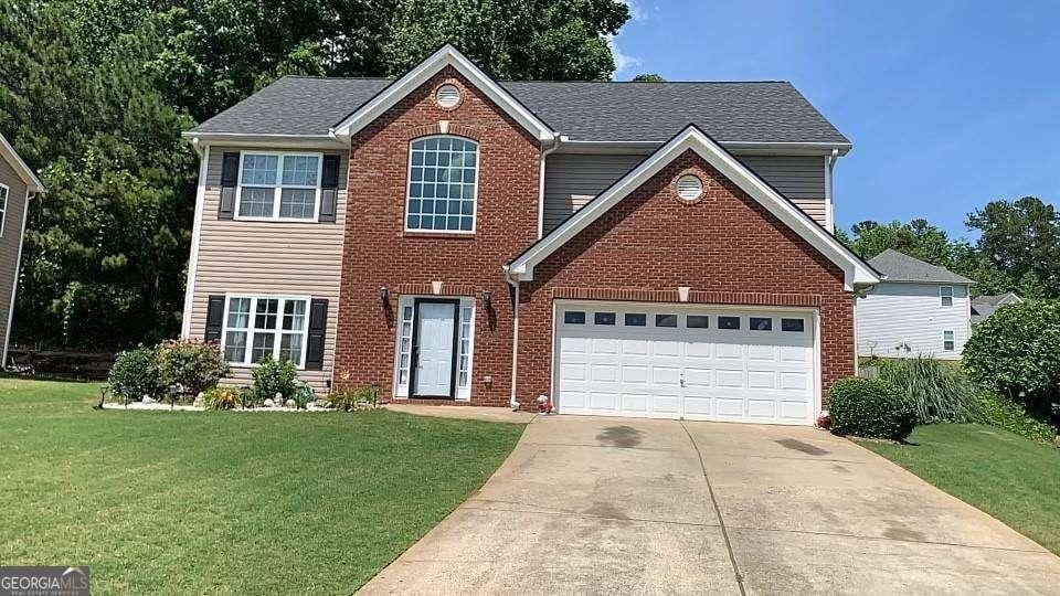 view of front of property with a garage and a front lawn