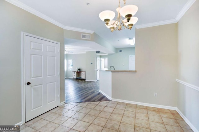 unfurnished dining area with light wood-type flooring, crown molding, a notable chandelier, and sink