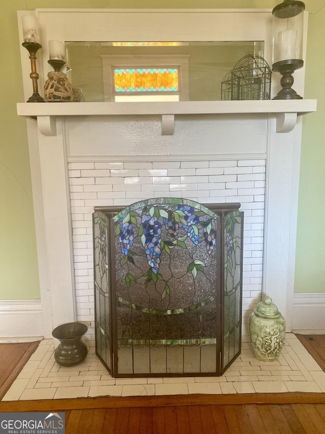 details featuring hardwood / wood-style floors and a brick fireplace