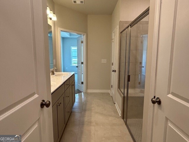 bathroom featuring tile patterned flooring, vanity, and an enclosed shower