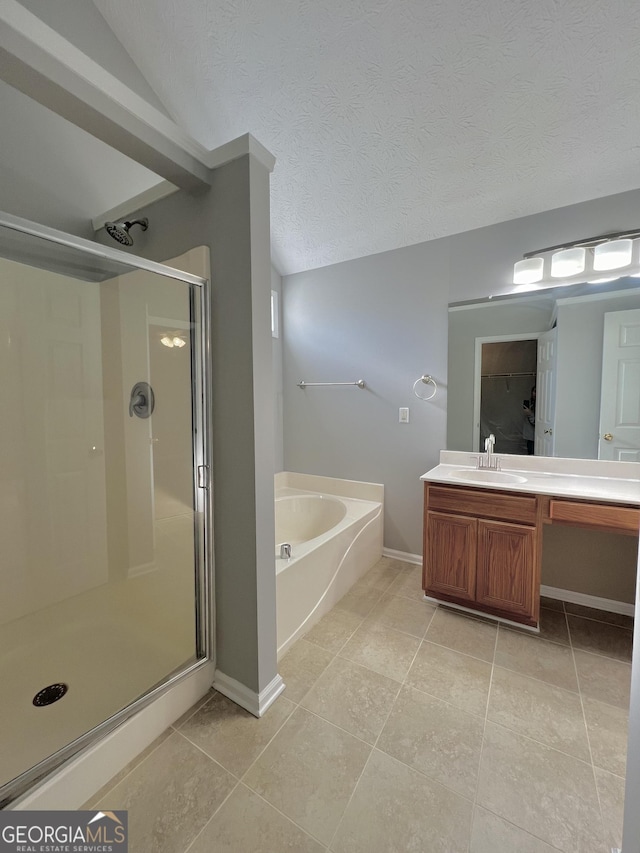 bathroom with tile patterned floors, vanity, shower with separate bathtub, and a textured ceiling