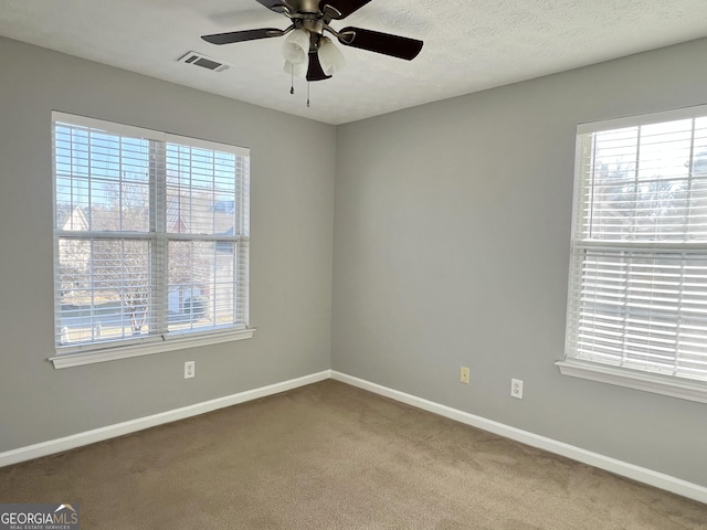 spare room featuring carpet flooring, ceiling fan, and a textured ceiling